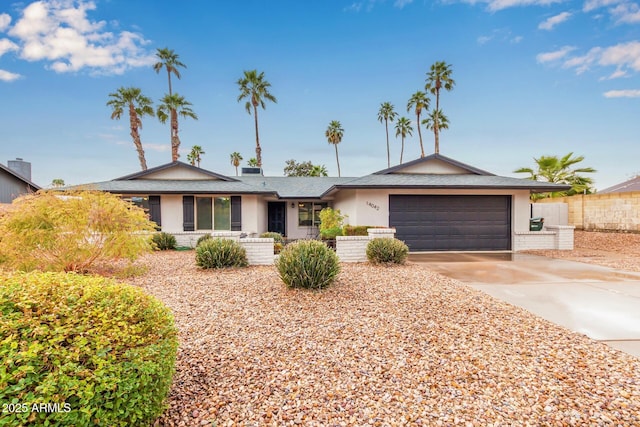 ranch-style home featuring a garage, concrete driveway, and stucco siding