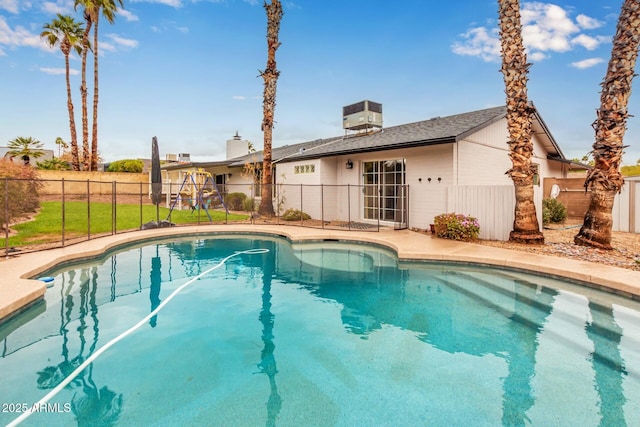 view of swimming pool with a fenced in pool, central AC, and fence