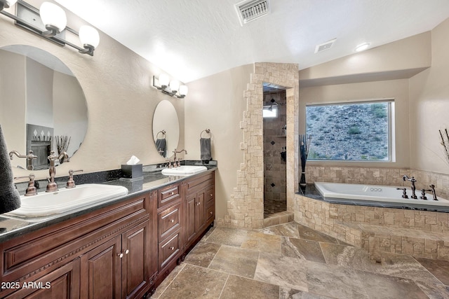 15413 S 31st Pl, Phoenix, AZ 85048 - bathroom featuring visible vents, stone tile floors, tiled shower, and a sink