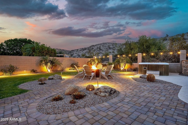 15413 S 31st Pl, Phoenix, AZ 85048 - patio terrace at dusk with a hot tub, an outdoor fire pit, fence, and a mountain view