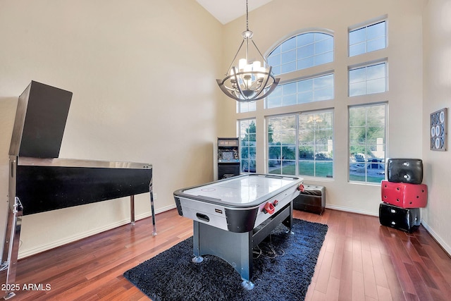 15413 S 31st Pl, Phoenix, AZ 85048 - playroom with baseboards, a towering ceiling, wood finished floors, and an inviting chandelier