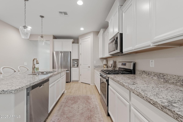 kitchen featuring recessed lighting, visible vents, appliances with stainless steel finishes, white cabinetry, and a sink