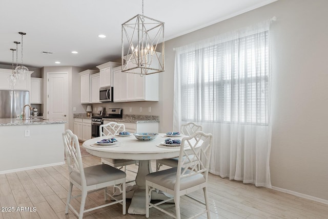 dining area featuring a notable chandelier, light wood finished floors, recessed lighting, visible vents, and baseboards