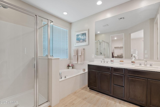 full bathroom featuring a stall shower, visible vents, a sink, and a bath