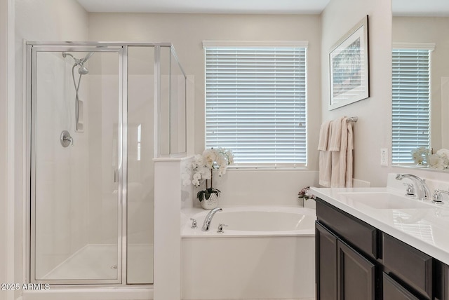 bathroom featuring a stall shower, a garden tub, and vanity