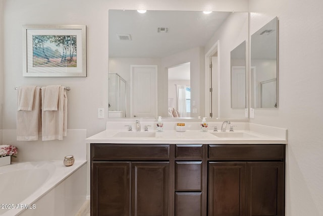 full bathroom featuring a bath, a sink, and visible vents