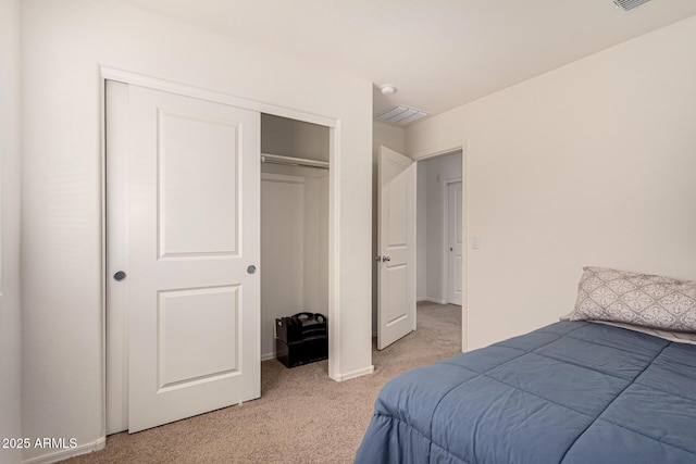 bedroom featuring visible vents, a closet, and light colored carpet