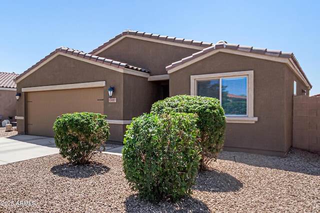 view of front facade featuring stucco siding, a tiled roof, concrete driveway, and an attached garage