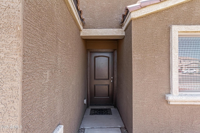 property entrance with stucco siding