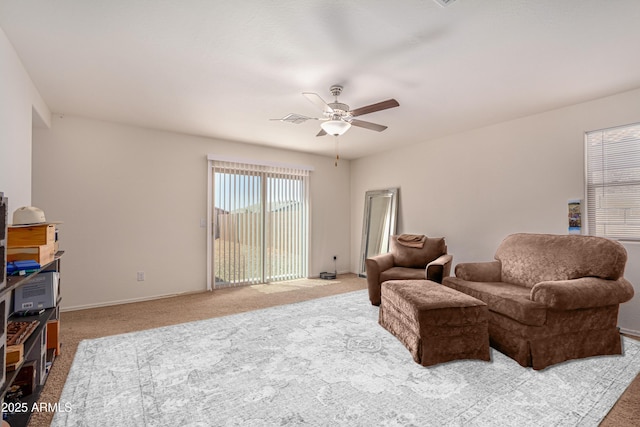 living area with visible vents, a ceiling fan, baseboards, and carpet floors