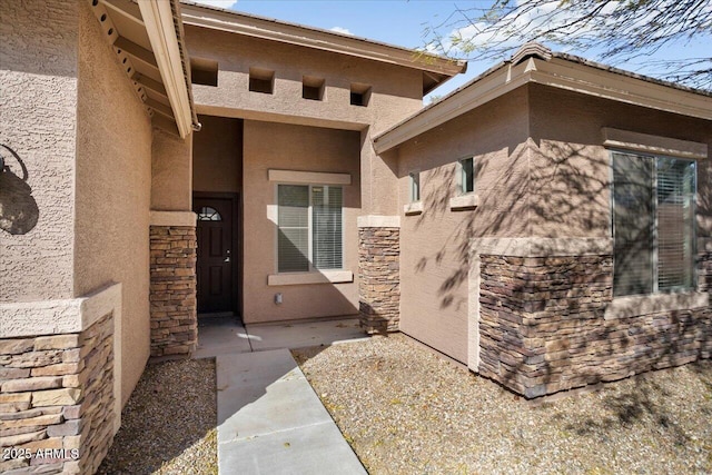 entrance to property featuring stone siding and stucco siding