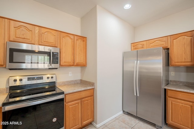 kitchen featuring light tile patterned floors, appliances with stainless steel finishes, and light countertops
