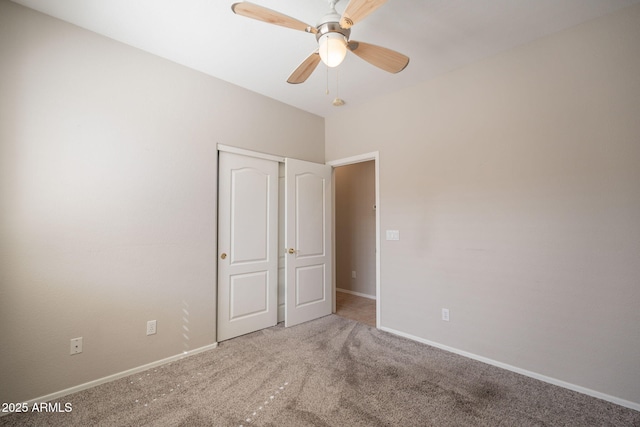 unfurnished bedroom with carpet floors, baseboards, a ceiling fan, and a closet
