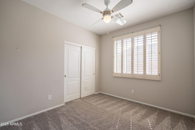 unfurnished bedroom featuring carpet floors, baseboards, visible vents, and a closet