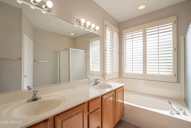 bathroom with double vanity, a sink, a garden tub, and a stall shower