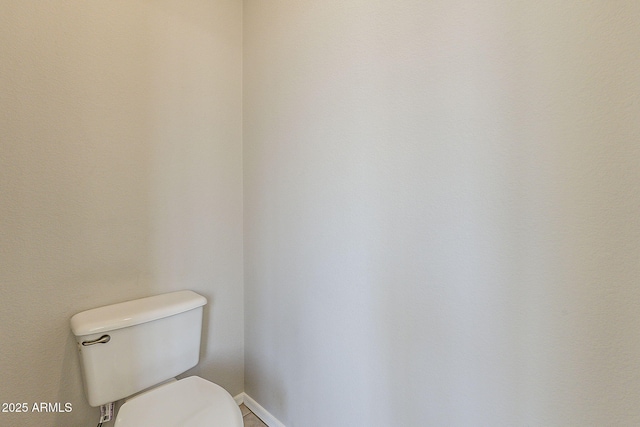 bathroom featuring toilet and baseboards