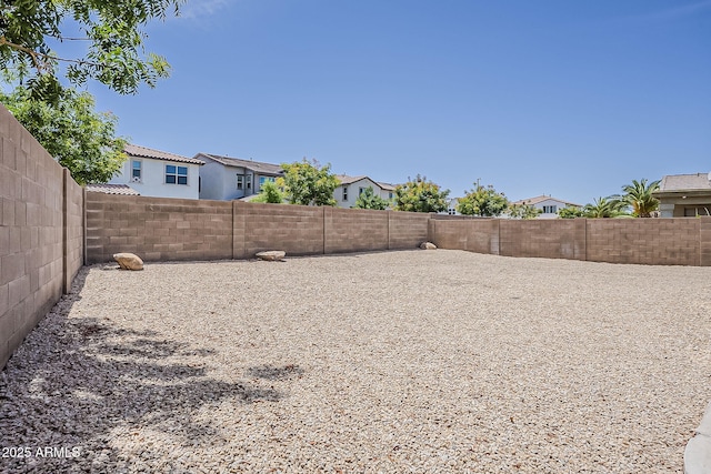 view of yard featuring a fenced backyard and a residential view