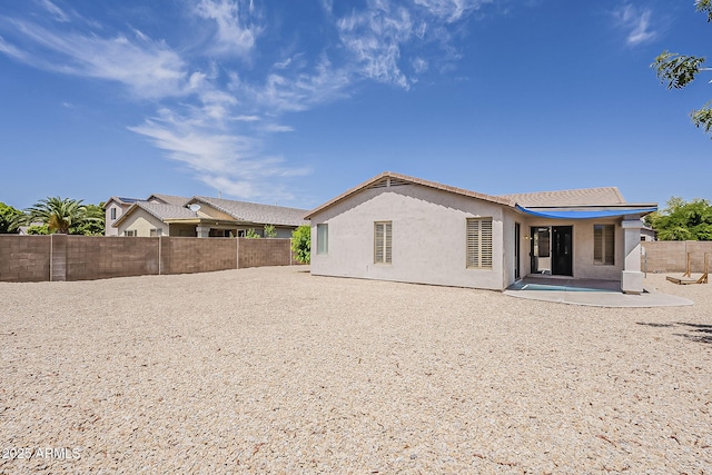 back of property featuring a fenced backyard, a patio area, and stucco siding