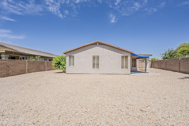 back of house featuring a patio, a fenced backyard, and stucco siding