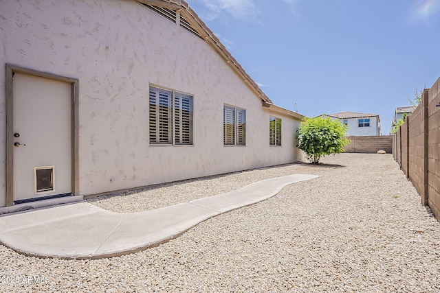 back of property featuring a fenced backyard and stucco siding
