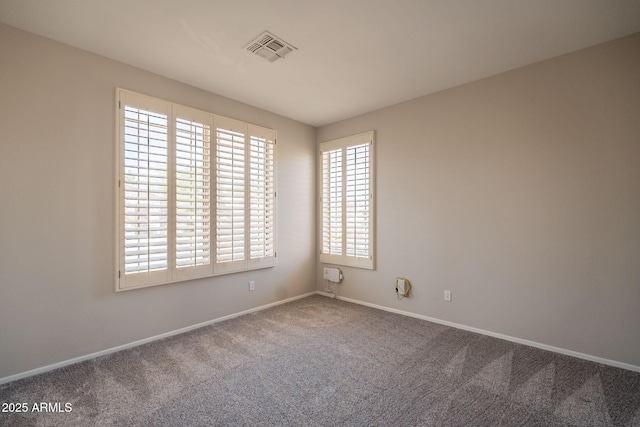 unfurnished room with visible vents, carpet, and baseboards