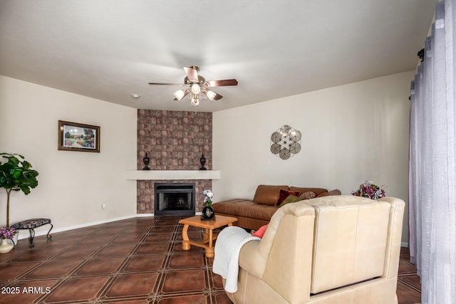 living room featuring a stone fireplace and ceiling fan