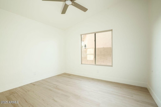 spare room featuring vaulted ceiling, light hardwood / wood-style floors, and ceiling fan