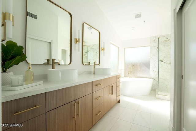 bathroom with tile patterned flooring, vanity, vaulted ceiling, and a tub to relax in