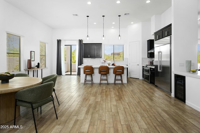 6133 E Dixileta Dr, Cave Creek, AZ 85331 - kitchen with wine cooler, appliances with stainless steel finishes, light countertops, a kitchen bar, and recessed lighting