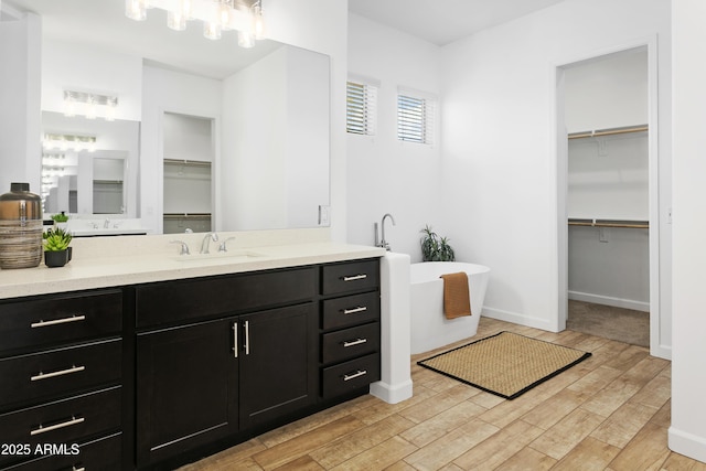 6133 E Dixileta Dr, Cave Creek, AZ 85331 - full bath with a walk in closet, a freestanding tub, vanity, and wood finished floors