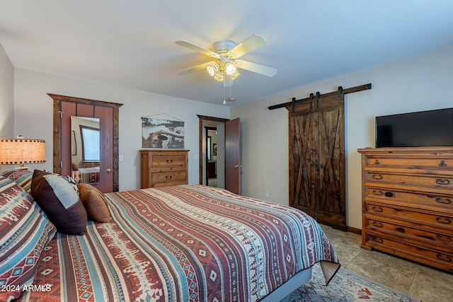 tiled bedroom with a barn door and ceiling fan