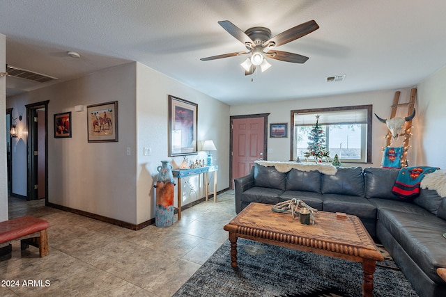 living room with ceiling fan and a textured ceiling