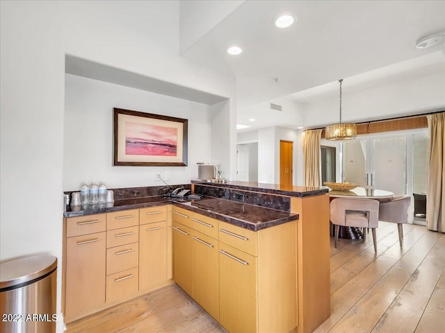 kitchen with light hardwood / wood-style flooring, light brown cabinetry, and kitchen peninsula