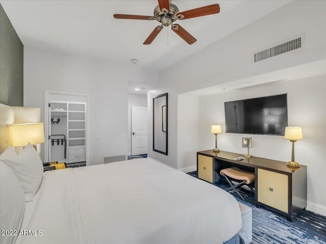 bedroom with a walk in closet and ceiling fan