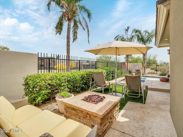 view of patio with a fenced in pool and a fire pit