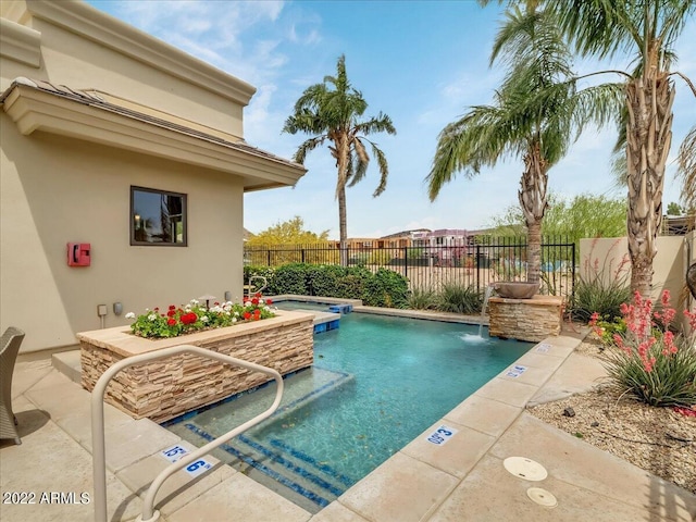 view of pool with a hot tub, a patio, and pool water feature