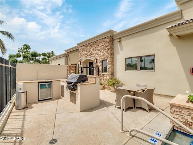 view of patio with area for grilling, beverage cooler, and grilling area