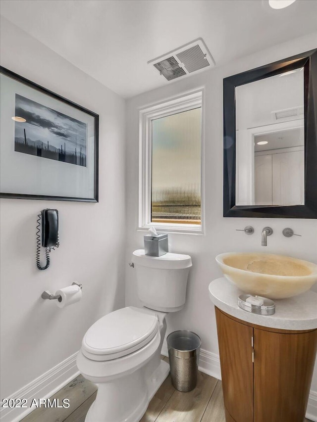 bathroom featuring vanity, toilet, and hardwood / wood-style floors