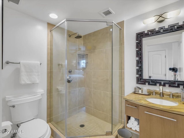 bathroom featuring vanity, a shower with shower door, and toilet