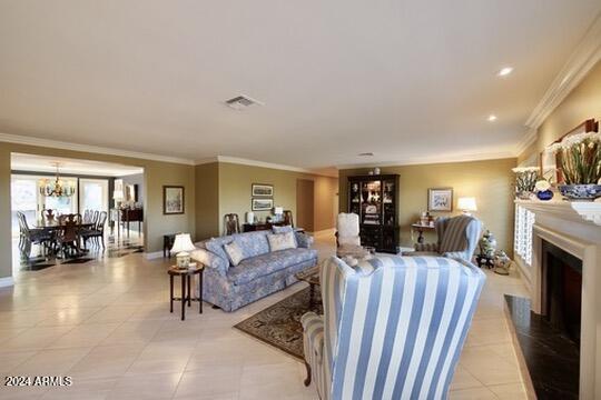 living room with ornamental molding and an inviting chandelier