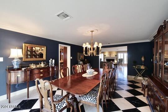 dining area featuring crown molding and a notable chandelier