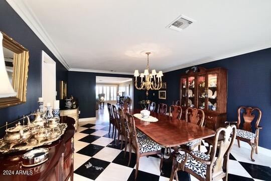 dining room with crown molding and a chandelier