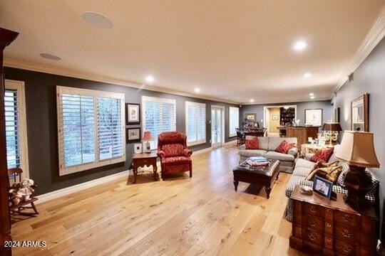 living room with light hardwood / wood-style floors, crown molding, and plenty of natural light