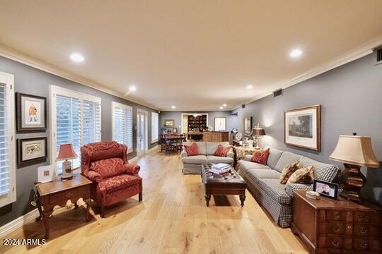 living room with crown molding and light hardwood / wood-style floors