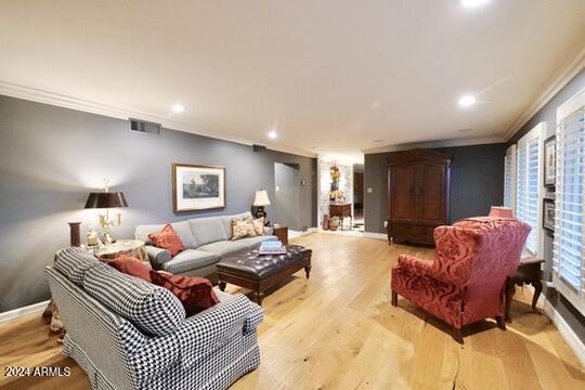 living room with light hardwood / wood-style floors and crown molding