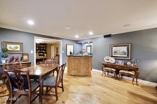 dining room with light hardwood / wood-style flooring and ornamental molding