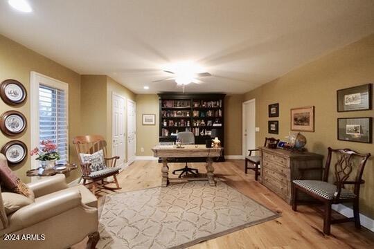 home office featuring wood-type flooring and ceiling fan