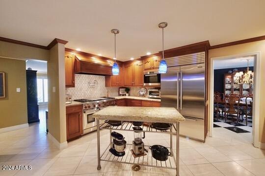 kitchen with custom exhaust hood, hanging light fixtures, light tile patterned floors, a kitchen breakfast bar, and high quality appliances