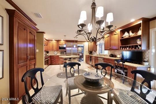 dining space with light tile patterned floors and a chandelier