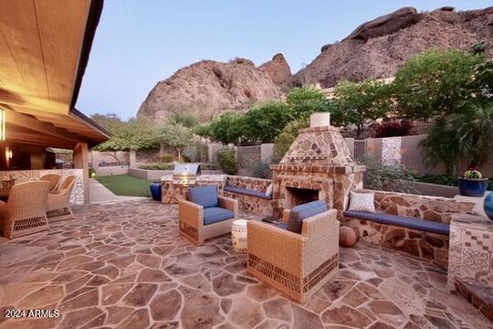 view of patio with a mountain view and an outdoor living space with a fireplace